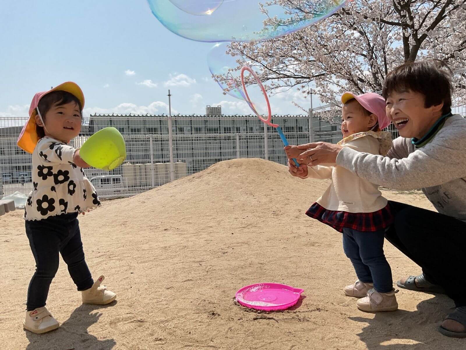 しゃぼん玉で遊ぶ先生と園児